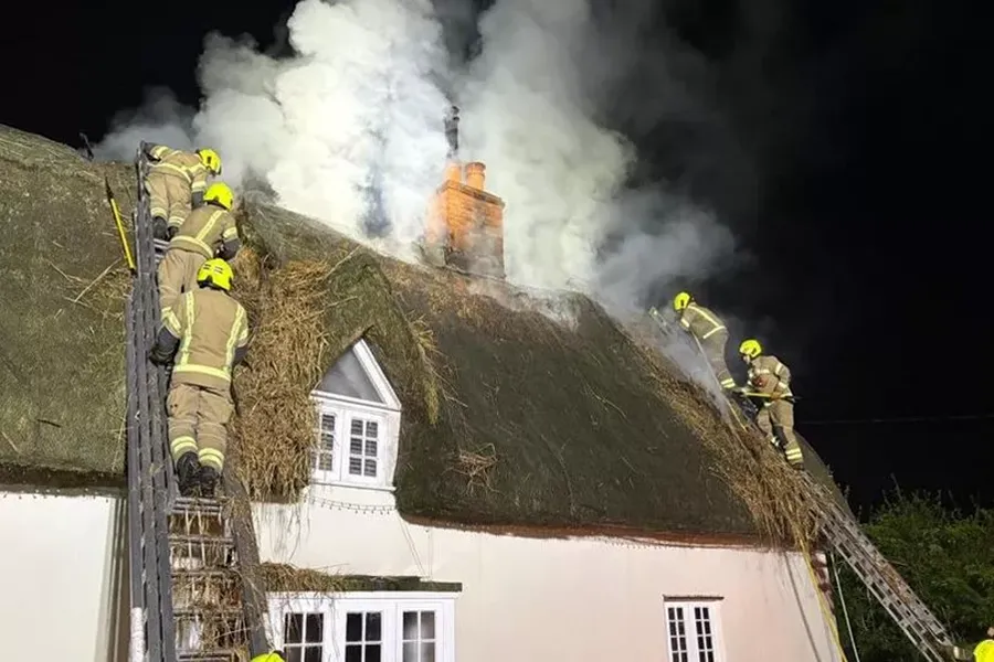 Fire crews extinguishing the thatch roof fire