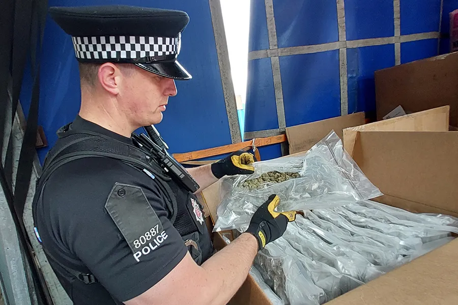 A police officer investigates the boxes of cannabis