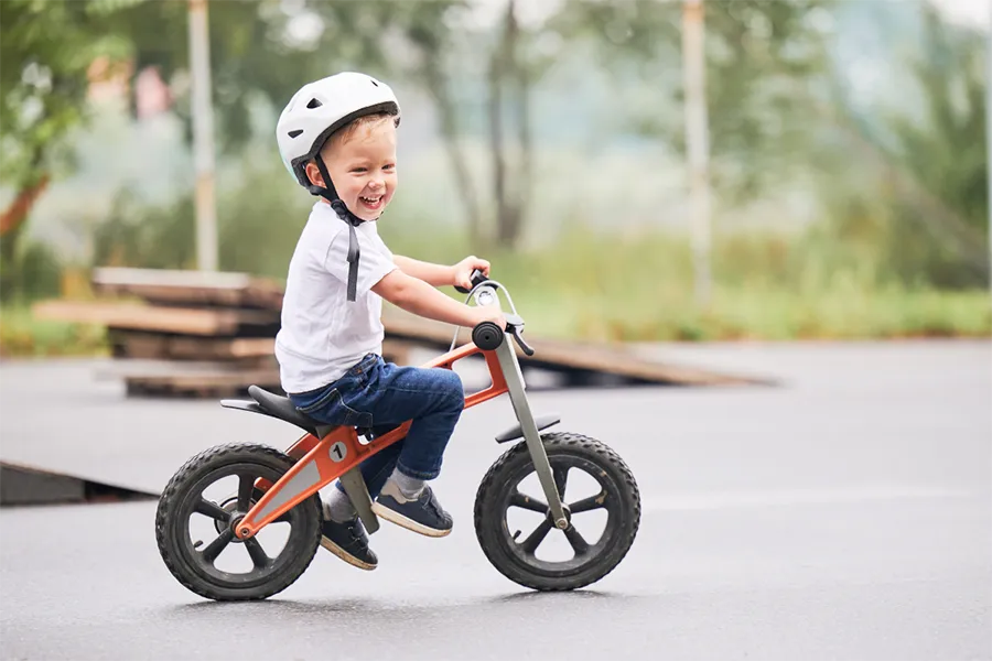 A Child Rides A Balance Bike