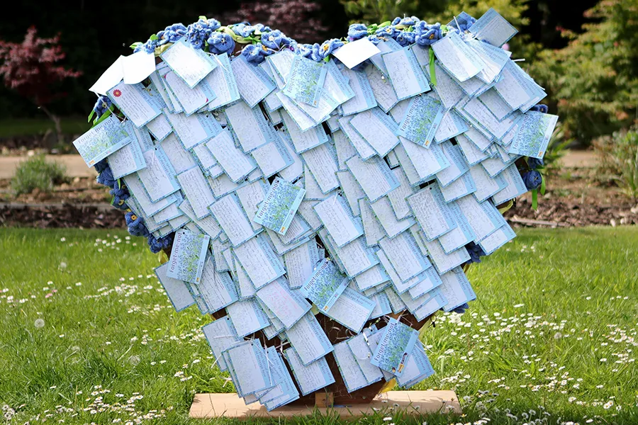 Forget-me-not heart made from many pieces of paper with dedications on them
