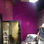 Decorating with purple glittering wallpaper in progress