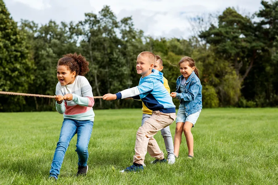children playing tug-of-war at a park