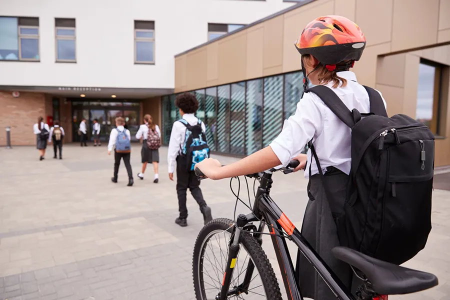 Child arriving at school with her bike.