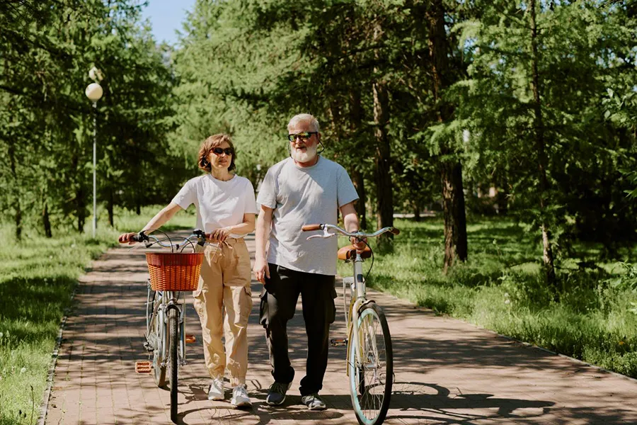 Couple walking with bikes in the summer sun