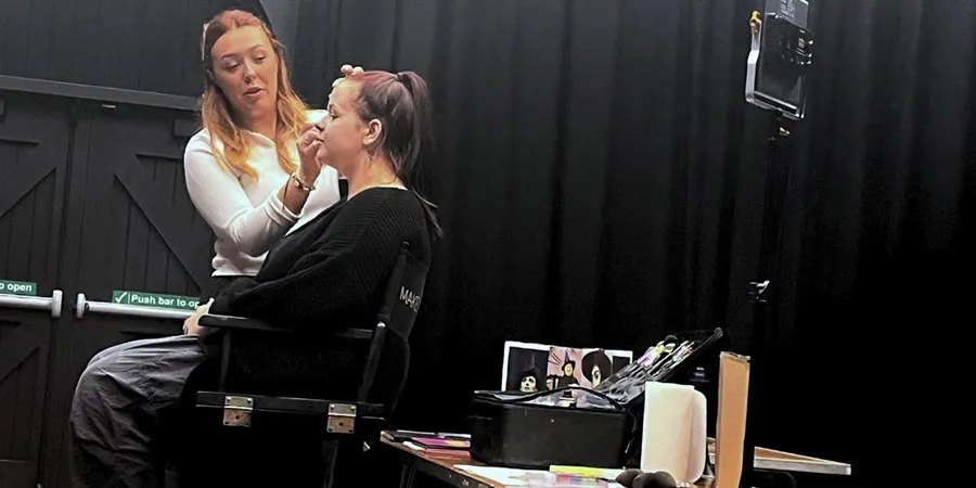 Lady applying makeup to an actor at Chelmsford Theatre