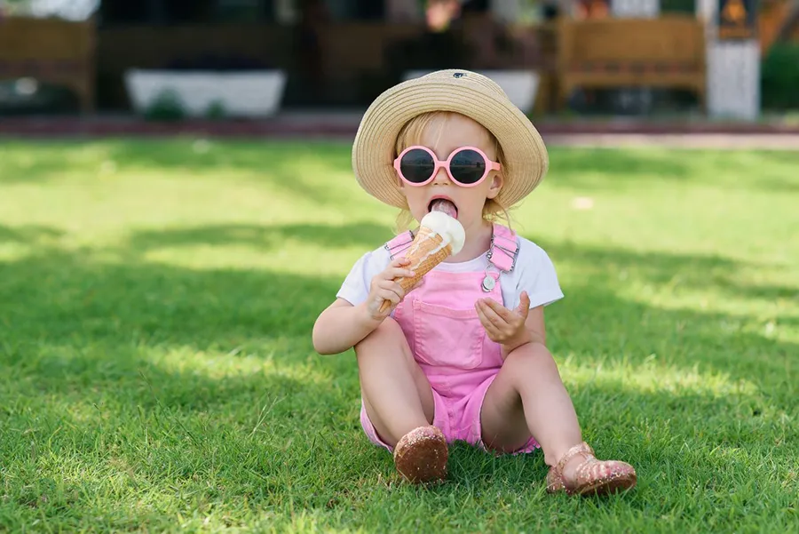 Toddler eating an ice cream in the shade