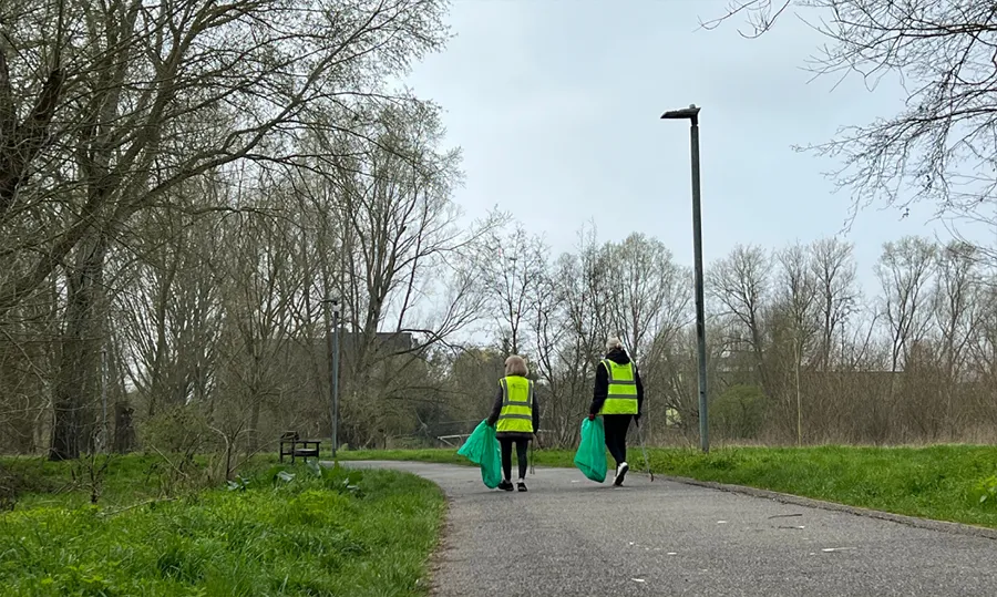 Two people litter-picking in a park